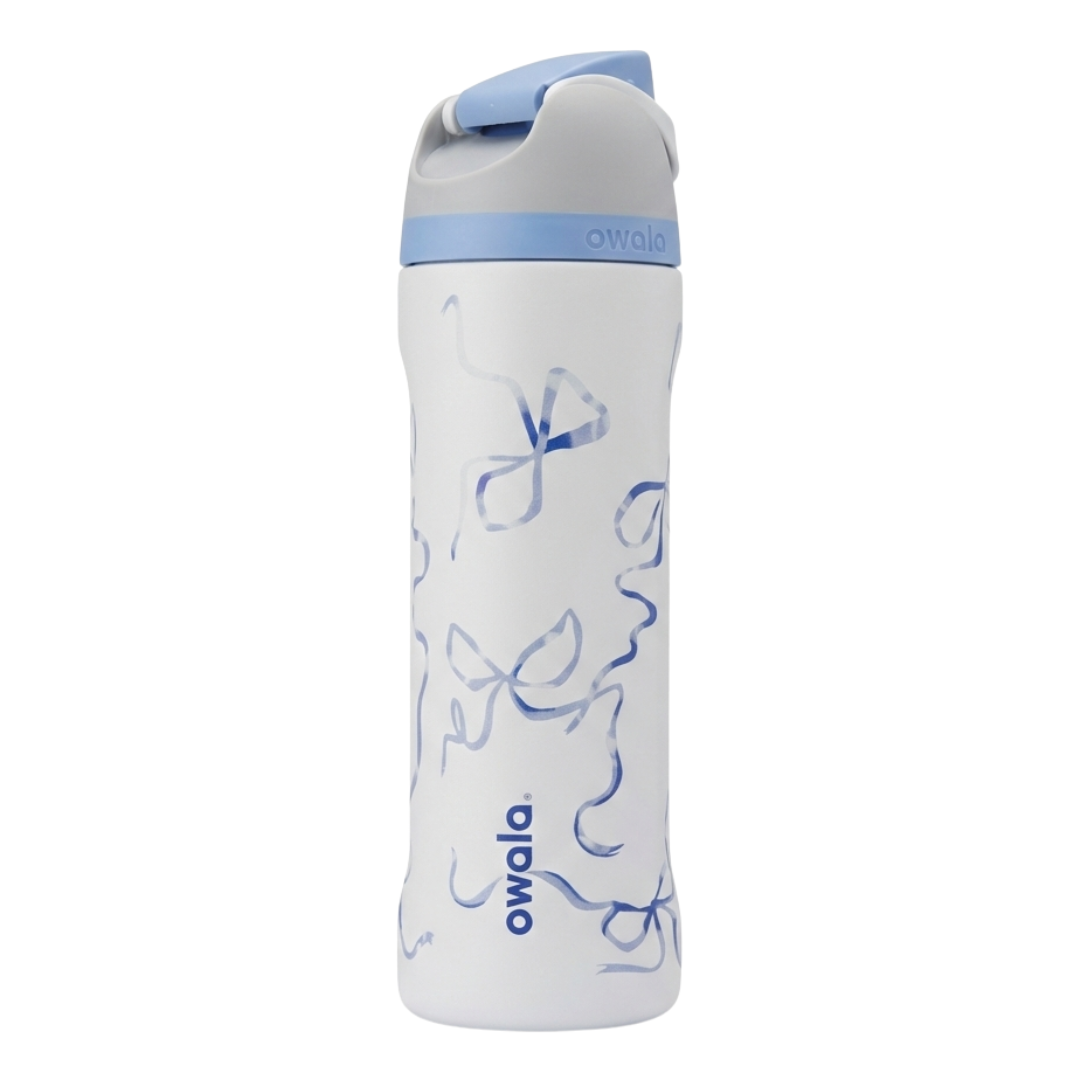 Botella térmica Owala FreeSip de 24 onzas en color blanco con un patrón de moños azules.