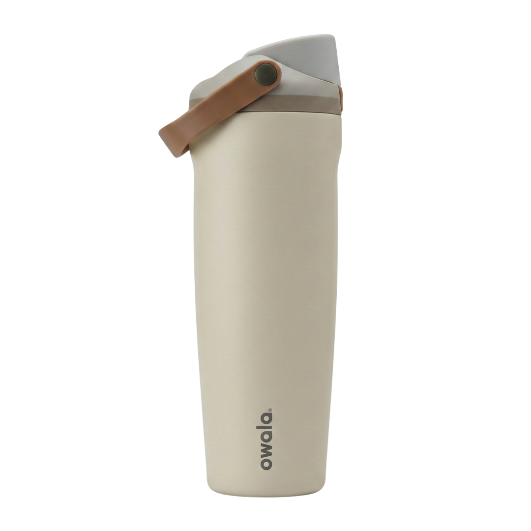 Botella térmica Owala FreeSip de 30 onzas con cuerpo en color blanco hueso mate. La tapa presenta una combinación de colores neutros: base en gris claro, cuerpo de la tapa en gris medio y el asa de transporte en color café suave. El logotipo de Owala resalta en la parte inferior del cuerpo en color gris oscuro.