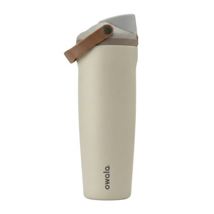 Botella térmica Owala FreeSip de 30 onzas con cuerpo en color blanco hueso mate. La tapa presenta una combinación de colores neutros: base en gris claro, cuerpo de la tapa en gris medio y el asa de transporte en color café suave. El logotipo de Owala resalta en la parte inferior del cuerpo en color gris oscuro.