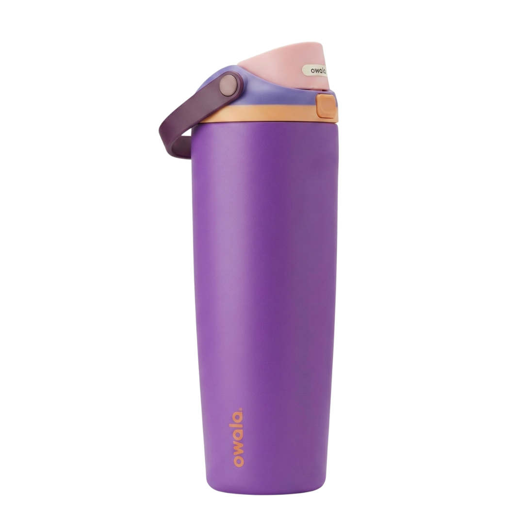 Botella térmica Owala FreeSip de 30 onzas con cuerpo en color morado uva mate. La tapa presenta una combinación llamativa: base en color melocotón, lila y rosado, asa de seguridad en morado oscuro. El logotipo de Owala resalta en la parte inferior del cuerpo en color melocotón.
