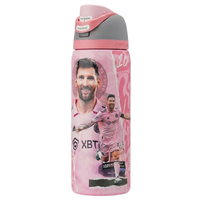Botella térmica Owala FreeSip de 32 onzas en color rosa pastel con diseño conmemorativo de Lionel Messi en el Inter Miami. Presenta al jugador sonriendo con la camiseta rosa oficial y otra imagen de él celebrando un gol. La tapa combina tonos de rosa claro, gris y un botón blanco. Incluye boquilla doble FreeSip y asa de transporte.