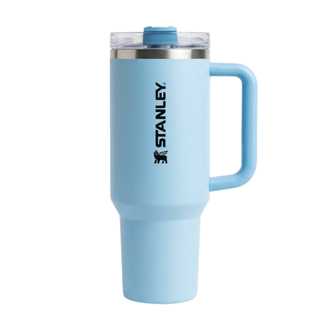Termo Stanley de 40 onzas modelo Quencher H2.0 en color celeste pastel (Frost). La tapa transparente incluye una cubierta giratoria en color celeste que combina con el cuerpo del vaso y el asa. Presenta el logotipo de Stanley en un tono azul marino profundo para crear un contraste elegante. Incluye pajilla transparente de alta resistencia.