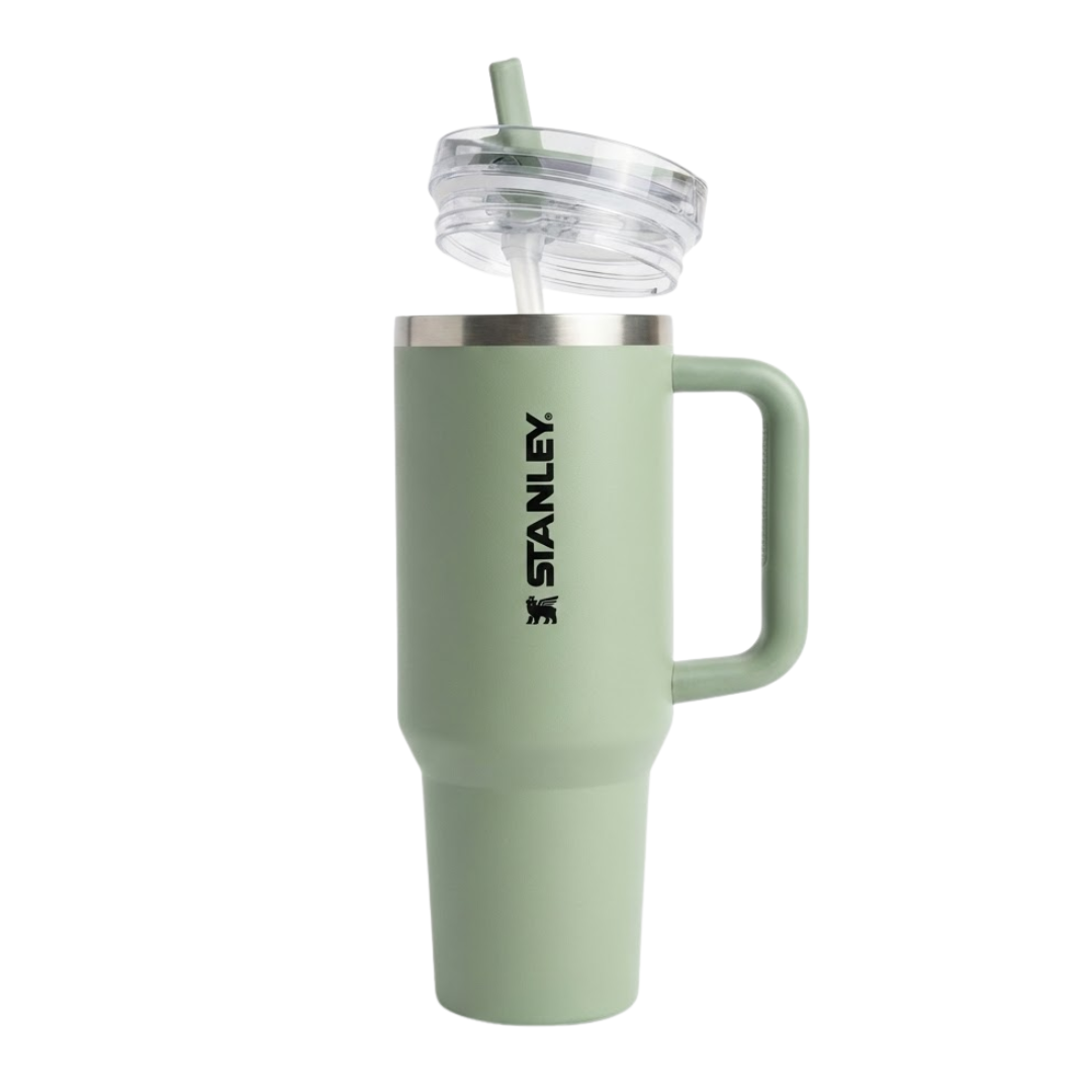 Termo Stanley Quencher H2.0 de 40 onzas en color verde salvia o verde cemento (Sage) con acabado mate. La tapa transparente tiene la pieza giratoria en color verde a juego. El asa ergonómica es de color verde con detalles en gris oscuro. Presenta el logotipo de Stanley grabado en color negro. Es un diseño de inspiración natural y moderna.