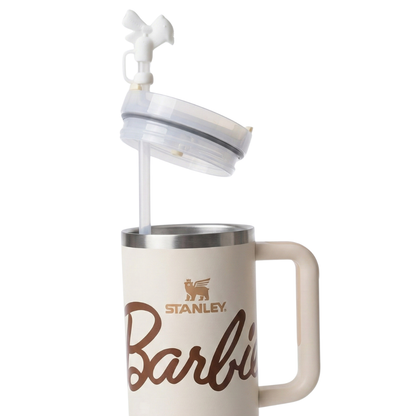 Vaso térmico Stanley x Barbie de 40 onzas en color beige crema (Birch) con acabado mate. Presenta un estampado sutil de estrellas y la silueta icónica de Barbie en tonos arena. El logotipo de Stanley y el nombre de Barbie resaltan en color marrón chocolate. Incluye la tapa FlowState™ con detalles en beige y el sello del 65 aniversario en la base.