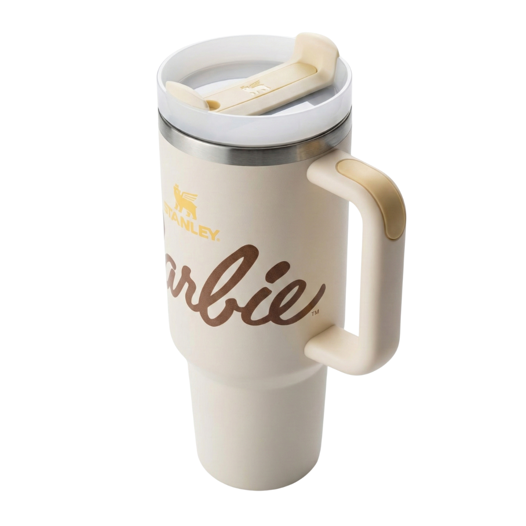 Vaso térmico Stanley x Barbie de 40 onzas en color beige crema (Birch) con acabado mate. Presenta un estampado sutil de estrellas y la silueta icónica de Barbie en tonos arena. El logotipo de Stanley y el nombre de Barbie resaltan en color marrón chocolate. Incluye la tapa FlowState™ con detalles en beige y el sello del 65 aniversario en la base.