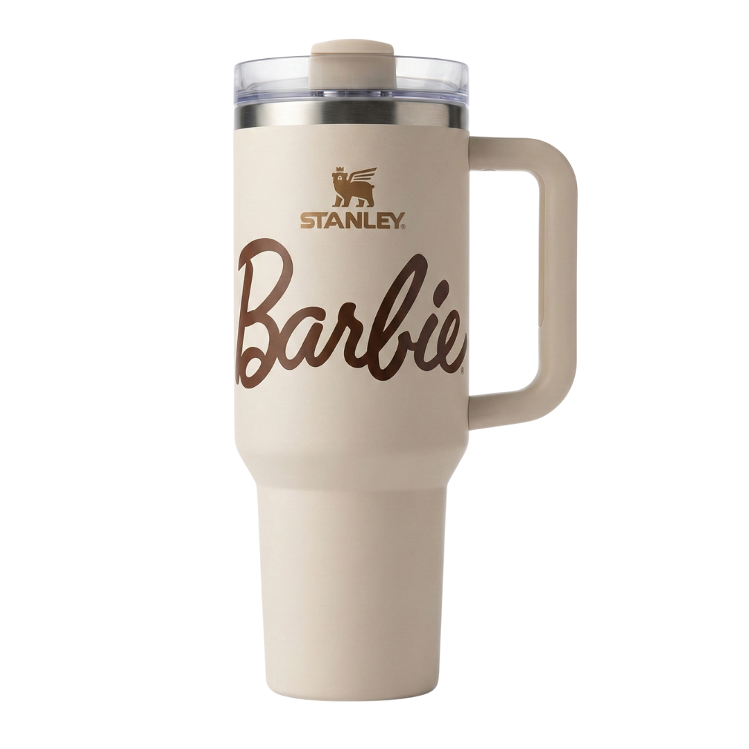 Vaso térmico Stanley x Barbie de 40 onzas en color beige crema (Birch) con acabado mate. Presenta un estampado sutil de estrellas y la silueta icónica de Barbie en tonos arena. El logotipo de Stanley y el nombre de Barbie resaltan en color marrón chocolate. Incluye la tapa FlowState™ con detalles en beige y el sello del 65 aniversario en la base.
