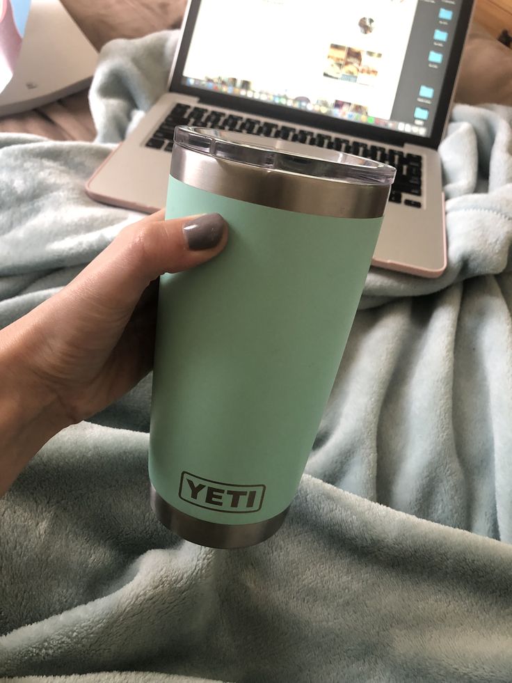 Vaso térmico Yeti Rambler de 20 onzas en color verde agua o menta (Seafoam) con acabado de pintura en polvo duradera. Presenta el logotipo de YETI grabado en la parte inferior sobre una base de acero inoxidable.